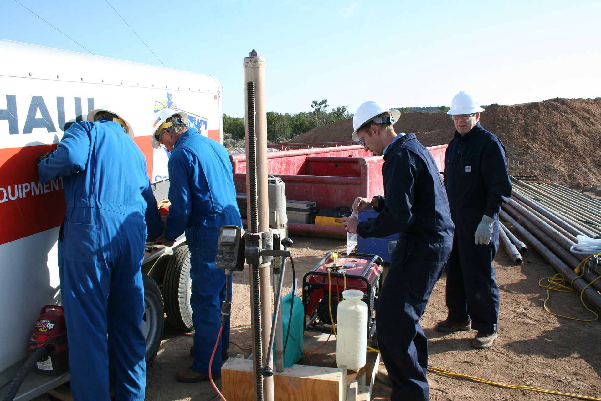 Dr. Reid Grigg (right) of the Petroleum Recovery Research Center (PRRC) looks on as members of the Southwest Regional Partnership on Carbon Sequestration (SWP) team work to collect noble gas samples as cores come out of the barrel. Analysis of noble gases was used to determine the natural helium concentrations, helium gradients, and 3He/4He ratios, which are being used to determine transport properties of the Kirtland and concomitant sealing behavior.