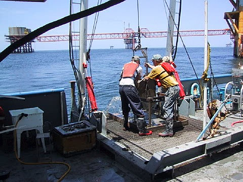 Collecting mud samples on an offshore rig.