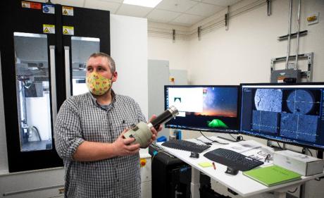A researcher with the enhanced tool to look at dynamic processes inside rock cores.