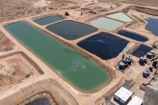 Evaporation ponds holding produced water amid the oil wells of the Permian Basin in New Mexico.